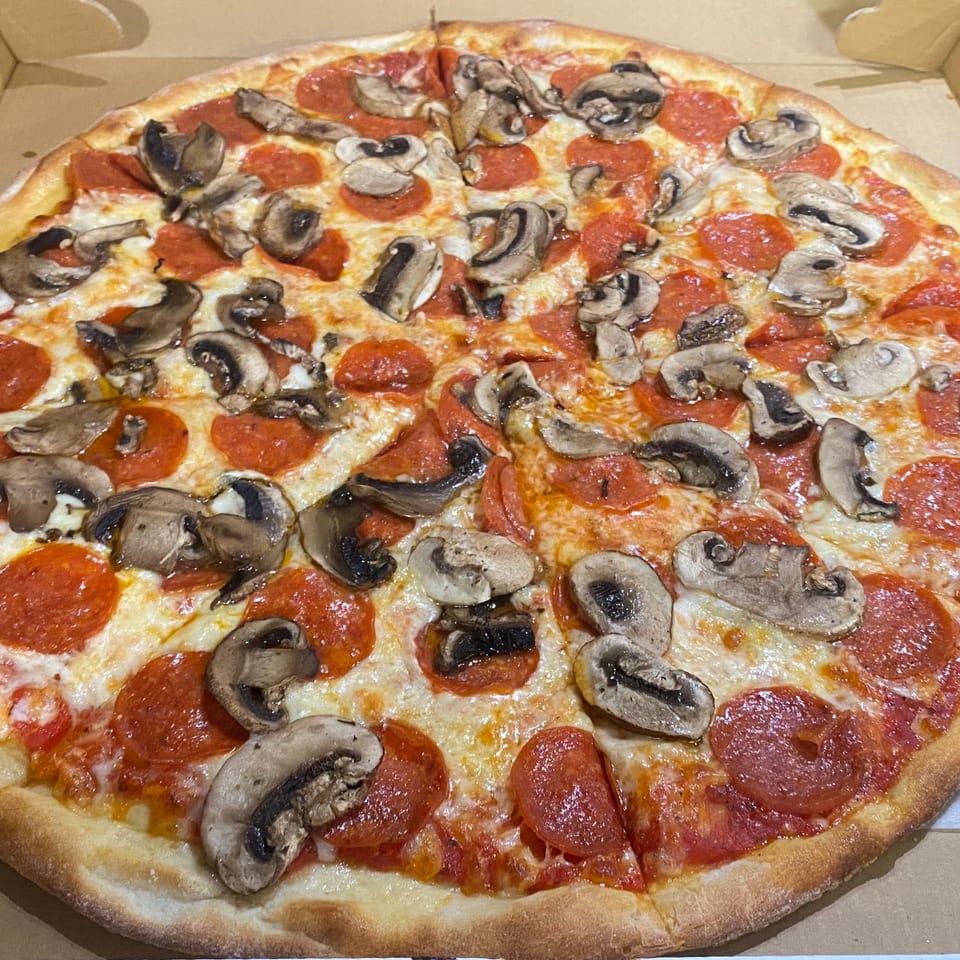 A whole Sofia Pizza pepperoni and mushroom pizza, sliced and ready to eat in a box.