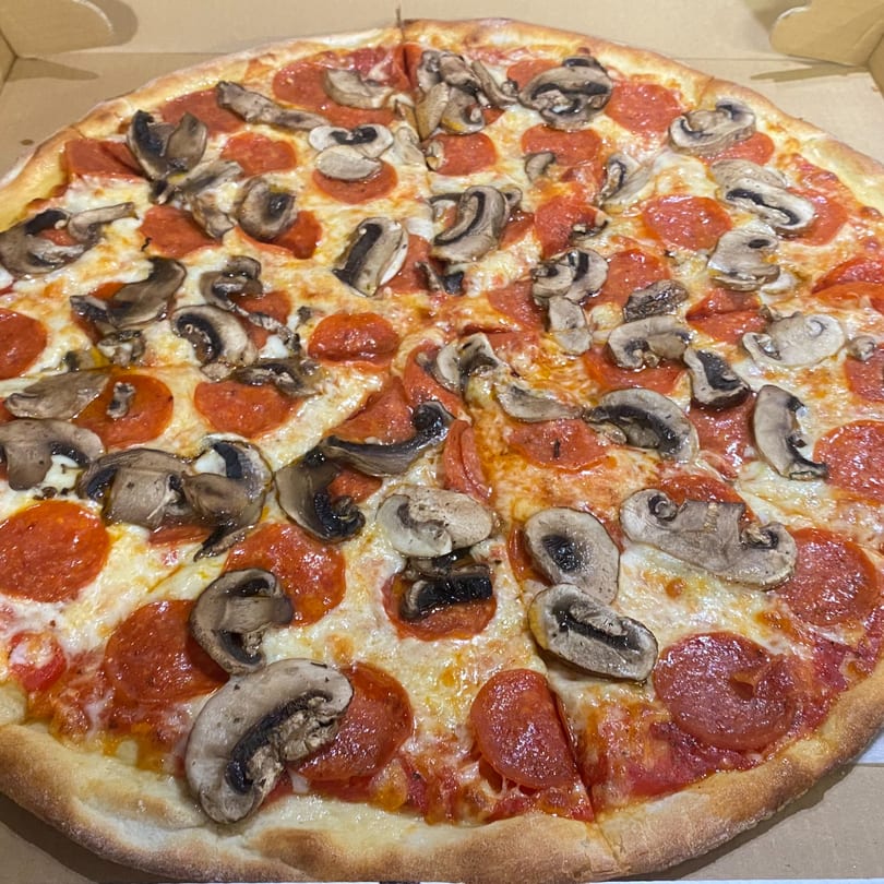 A whole Sofia Pizza pepperoni and mushroom pizza, sliced and ready to eat in a box.